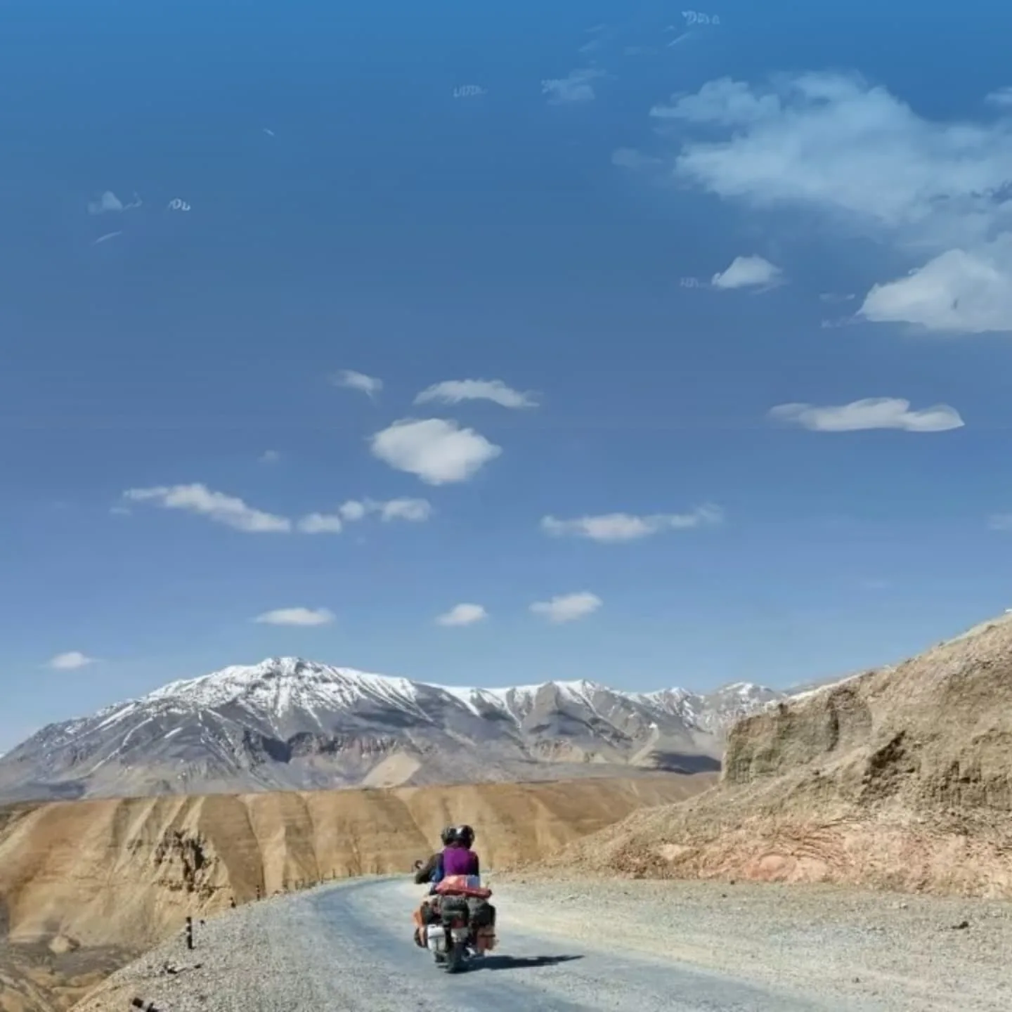 Travellers taking in a wide Himalayan landscape