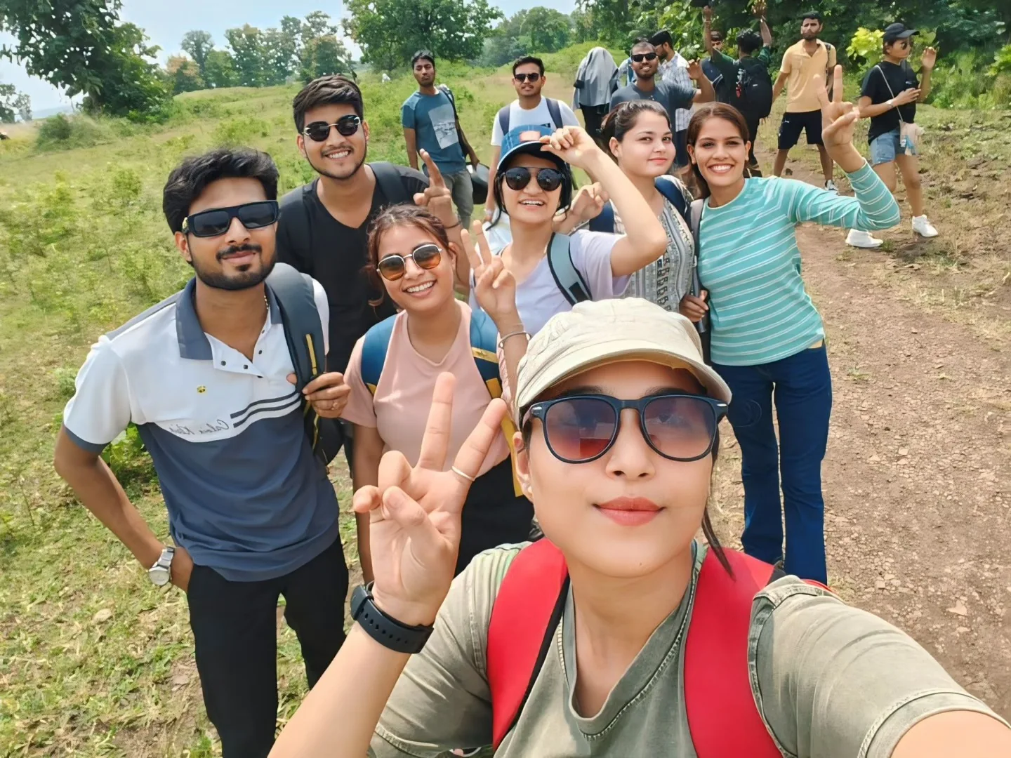 FUN TOUR travellers pausing together on a green hill trail